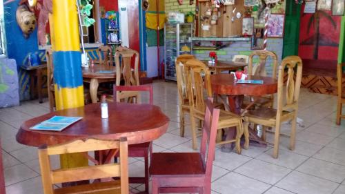 a restaurant with wooden tables and chairs in a room at Hostal Maria in Rivas