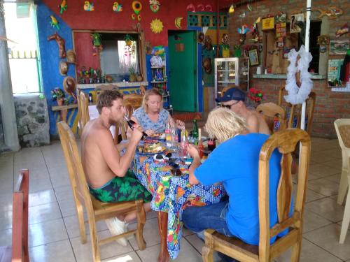 a group of people sitting around a table in a restaurant at Hostal Maria in Rivas