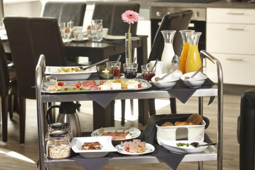 Una mesa con platos de comida encima en Kühne's 4 Sterne Komfort-Apartments, en Braunlage