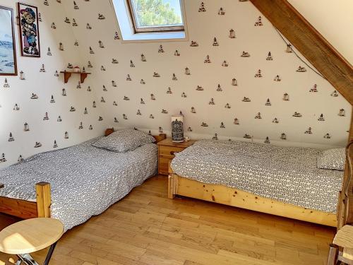 two beds in a room with a wall with trees on it at Villa 5 pièces avec jardin, à 400m de la plage et 600m des commerces, wifi et barbecue inclus - FR-1-361-20 in Jullouville-les-Pins