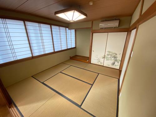 una habitación vacía con una habitación con ventanas y una habitación con en lifeone club en Hiroshima