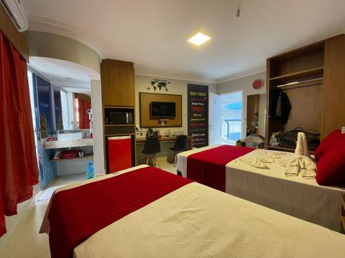 um quarto de hotel com duas camas e uma televisão em Araras Apart Service I em Caldas Novas