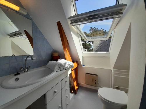 a bathroom with a sink and a toilet and a window at Villa Carnac, 3 pièces, 6 personnes - FR-1-477-207 in Carnac