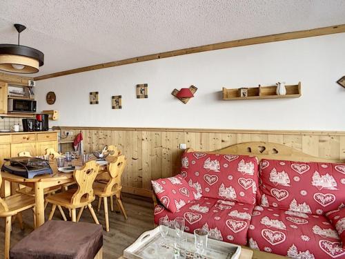 un salon avec un canapé rouge et une table dans l'établissement Appartement rénové, skis aux pieds, balcon sud, 40 m² 6 pers, Internet inclus - FR-1-344-751, aux Menuires