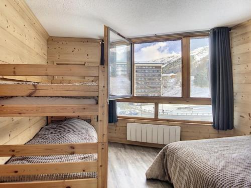- une chambre avec 2 lits superposés et une grande fenêtre dans l'établissement Appartement rénové, skis aux pieds, balcon sud, 40 m² 6 pers, Internet inclus - FR-1-344-751, aux Menuires