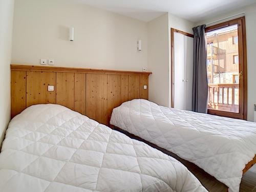two beds in a bedroom with a window at Appartement rénové 4 Pièces · Proche des pistes · Balcon · Sauna · Hammam · WIFI - FR-1-344-770 in Levassaix