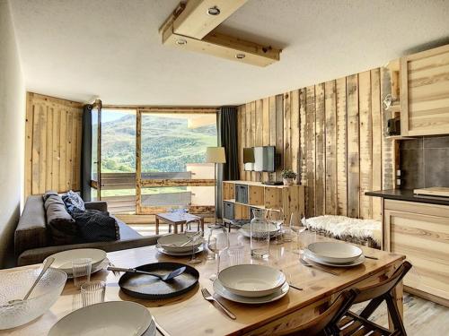 d'un salon avec une table et des plaques de cuisson. dans l'établissement Bel Appart Rénové · 6 Pers · Pied des Pistes · Balcon · 2 Flocons Bronze - FR-1-344-776, aux Menuires