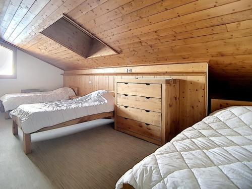 a bedroom with two beds and a wooden ceiling at Appartement spacieux et rénové, 10 personnes, 4 Flocons OR, sauna et hammam - FR-1-344-786 in Levassaix