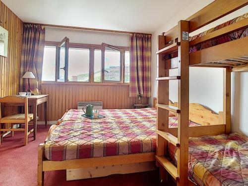 une chambre avec un lit superposé et un bureau dans l'établissement Charmant T2 avec Balcon Sud, Proche Pistes et Commerces, Idéal Familles, Les Belleville - FR-1-344-838, aux Menuires