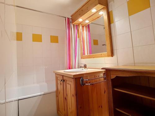une salle de bain avec un lavabo, un miroir et une baignoire dans l'établissement Charmant T2 avec Balcon Sud, Proche Pistes et Commerces, Idéal Familles, Les Belleville - FR-1-344-838, aux Menuires