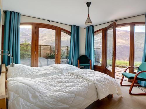 a bedroom with a bed and two chairs and windows at Appartement de standing rénové aux Belleville avec balcon, accès pistes, WiFi, sauna et hammam - FR-1-344-808 in Levassaix
