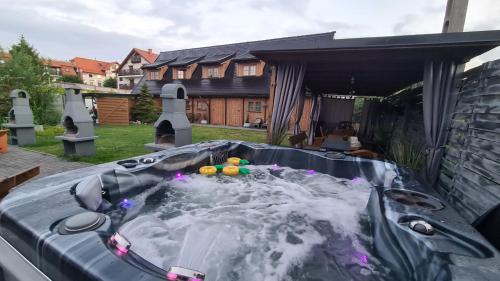 a hot tub in the backyard of a house at Domki Drewniane Całoroczne in Krynica Morska