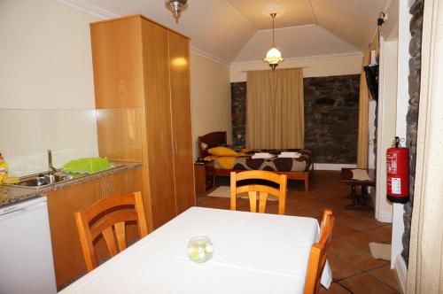 een keuken en een woonkamer met een tafel en stoelen bij Herdade do Pedregal in Ponta do Pargo