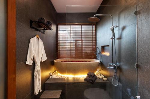 a bathroom with a large tub and a shower at Vin Villa Canggu 3 BR with private pool in Canggu