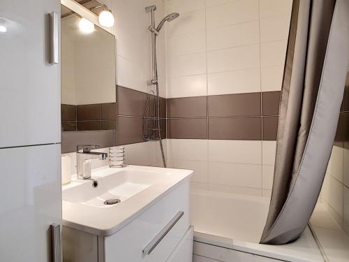 een witte badkamer met een wastafel en een douche bij Studio Les Menuires, 1 pièce, 2 personnes - FR-1-344-888 in Les Menuires