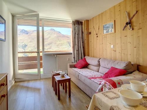 un salon avec un canapé et une table dans l'établissement Duplex rénové lumineux, balcon sud-ouest, pied des pistes, 5 pers., TV, cuisine équipée - FR-1-344-925, aux Menuires