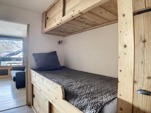 - un lit dans un cadre de lit en bois dans l'établissement Studio rénové au centre avec balcon - FR-1-344-926, aux Menuires