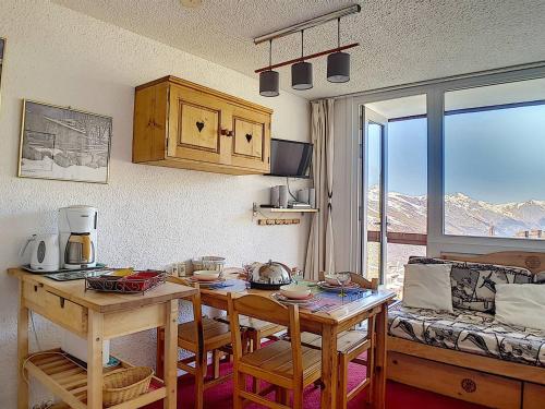 une cuisine avec une table et une salle à manger avec vue dans l'établissement Duplex skis aux pieds avec balcon – 4 pers, 2 flocons - FR-1-344-943, aux Menuires