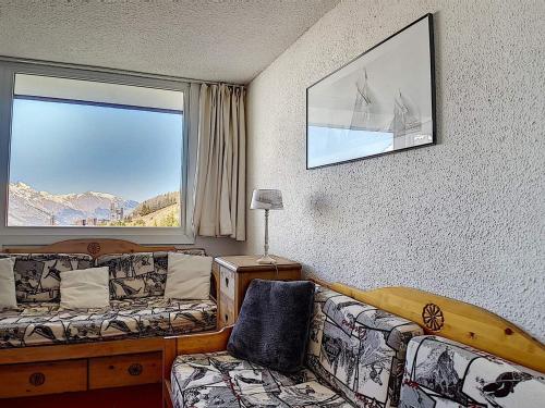 une chambre d'hôtel avec un canapé et une fenêtre dans l'établissement Duplex skis aux pieds avec balcon – 4 pers, 2 flocons - FR-1-344-943, aux Menuires