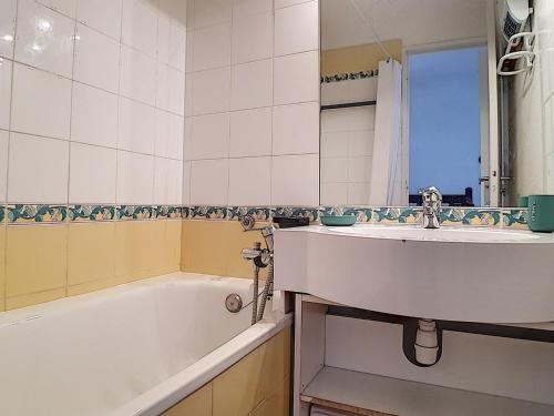 une salle de bain avec un lavabo, une baignoire et un miroir dans l'établissement Duplex skis aux pieds avec balcon – 4 pers, 2 flocons - FR-1-344-943, aux Menuires