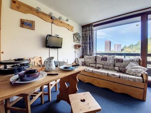 un salon avec un canapé et une table dans l'établissement Studio agréable Au pied des pistes. Balcon Nord - FR-1-344-941, aux Menuires