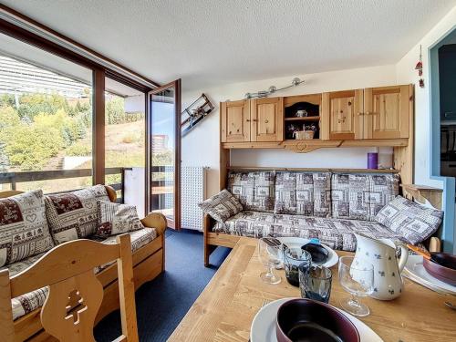 un salon avec un canapé et une table dans l'établissement Studio agréable Au pied des pistes. Balcon Nord - FR-1-344-941, aux Menuires