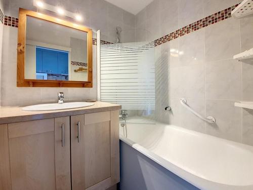 une salle de bain avec un lavabo, une baignoire et un miroir dans l'établissement Studio agréable Au pied des pistes. Balcon Nord - FR-1-344-941, aux Menuires