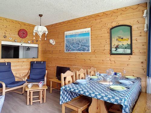 une salle à manger avec une table et des chaises bleues dans l'établissement Appartement Lumineux 6 Pers. · Balcon Sud · Accès Direct aux Pistes · Garage en Option · La Croisette - FR-1-344-1017, aux Menuires