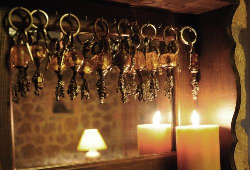 a bunch of utensils hanging on a wall with candles at Nymfes Guesthouse in Synikia Mesi Trikalon
