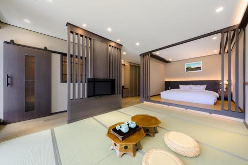 a bedroom with a bed and a table and chairs at Hotel HaruSida in Seogwipo