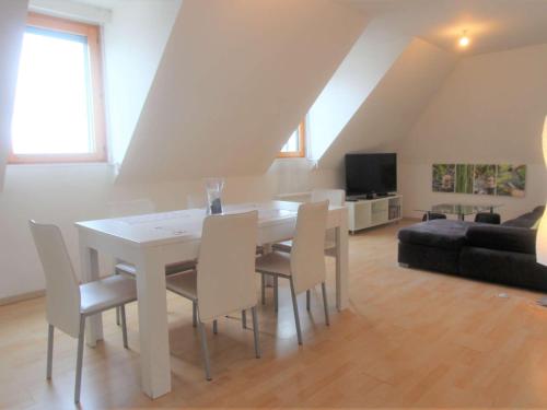 un salon avec une table et des chaises blanches dans l'établissement Appartement cosy au cœur de La Forêt-Fouesnant, à 5 min de la plage - FR-1-481-121, à La Forêt-Fouesnant