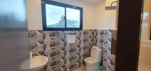 bagno con lavandino, servizi igienici e finestra di West Atlantic Inn a Concepcion