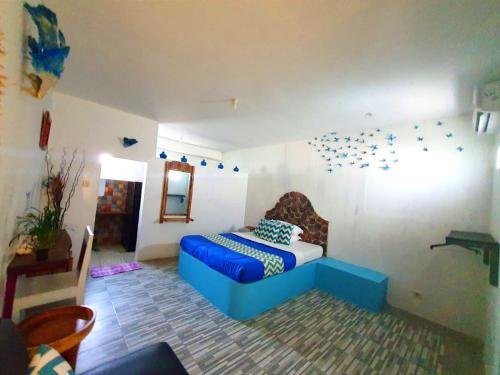 - une chambre avec un canapé bleu dans l'établissement Blue Coral Homestay, à Karimunjawa
