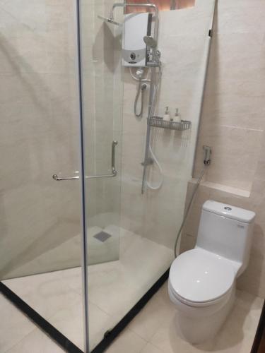 La salle de bains est pourvue de toilettes et d'une douche en verre. dans l'établissement Haven Vietnam, à Quy Nhơn