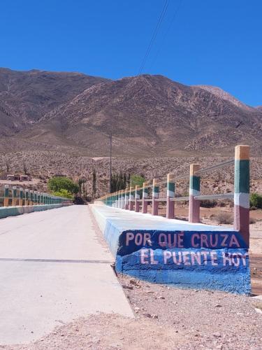 a sign on the side of a road with mountains in the background at Posada Huacalera (Tropico de Capricornio) in Huacalera