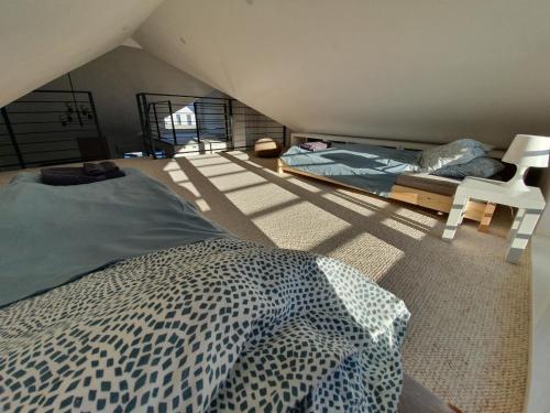 - une chambre mansardée avec un lit et une chaise dans l'établissement Apartament Piaskowa Duna, à Mechelinki