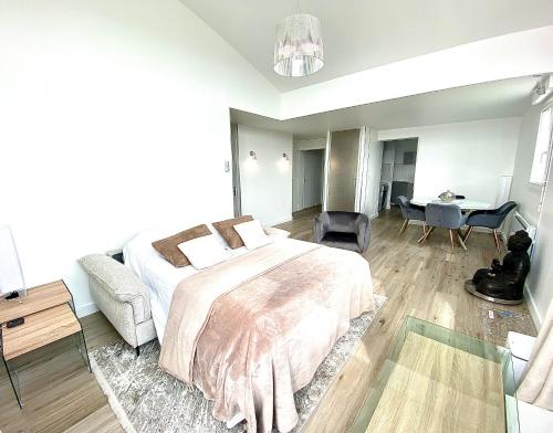 une chambre avec un grand lit et un bureau dans l'établissement L' Évéa Rooftop, à Le Relecq-Kerhuon