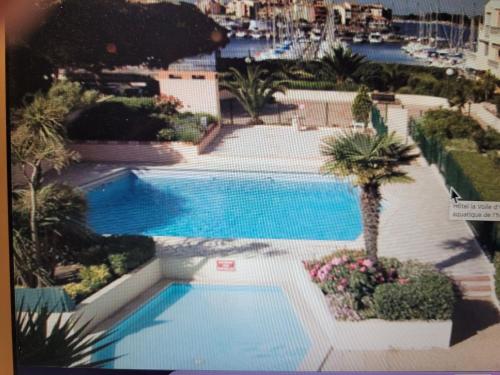 une vue aérienne d'une piscine avec des palmiers dans l'établissement STUDIO CAP D AGDE VUE PORT, au Cap d'Agde
