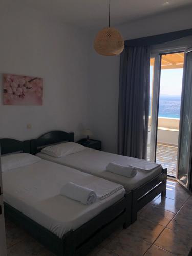 a bedroom with two beds and a view of the ocean at Meltemi Tinos in Agios Romanos