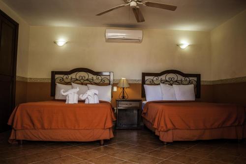 a hotel room with two beds with towels on them at Maya Campeche Hotel in Campeche