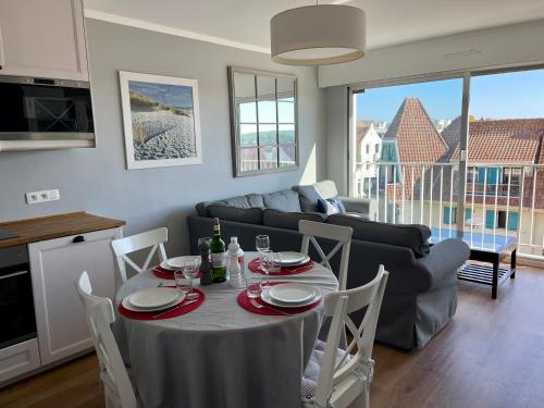 une cuisine et un salon avec une table et un canapé dans l'établissement Le Touquet - Superbe appartement 3 chambres - Proche mer & centre - Wifi, à Le Touquet-Paris-Plage