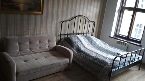 a bedroom with a bed and a chair and a window at Centrum Apartament Sędziego in Świdnica
