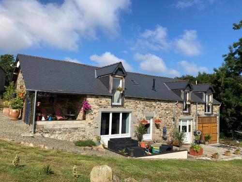 a stone house with a black roof at Ash Tree in Vire