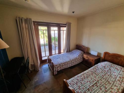 ein Schlafzimmer mit zwei Betten und einem Fenster in der Unterkunft Casa aconchegante e grande no Circuito das Águas Paulista - cem por cento privativa in Amparo