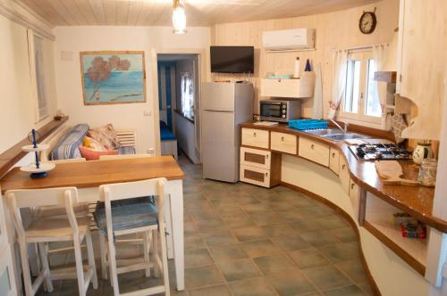 una piccola cucina con bancone e tavolo in una stanza di Nel verde del Villaggio - Casetta Celeste a Gonnesa