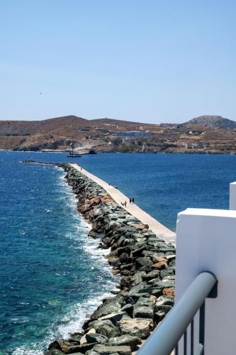 a retaining wall next to the water with a pier at Nisaki Hotel & Elite Suites in Ermoupoli