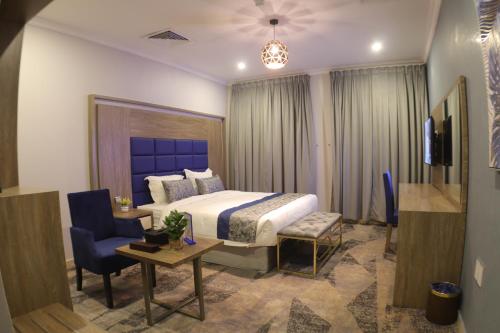 a hotel room with a bed and a table and chairs at Swat Olaya Hotel Apartments in Al Khobar
