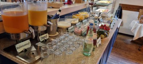 a counter with glasses and bottles of drinks on it at Hohes Haus in Greetsiel