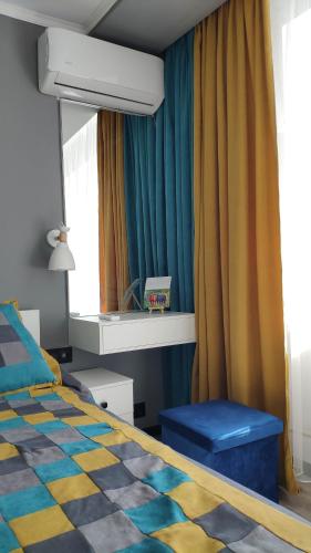 a bedroom with a bed and a mirror and curtains at Apartment on Panfilova 114 in Almaty