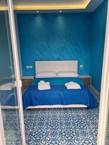 a blue bedroom with a bed with two towels on it at Esposito Guest House in Procida